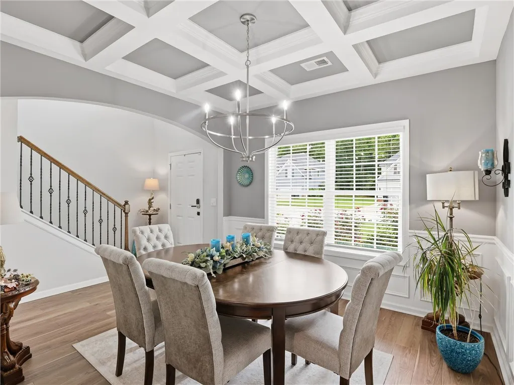 Ornate coffered ceilings and rich hardwood flooring define this elegant dining room, perfect for entertaining.