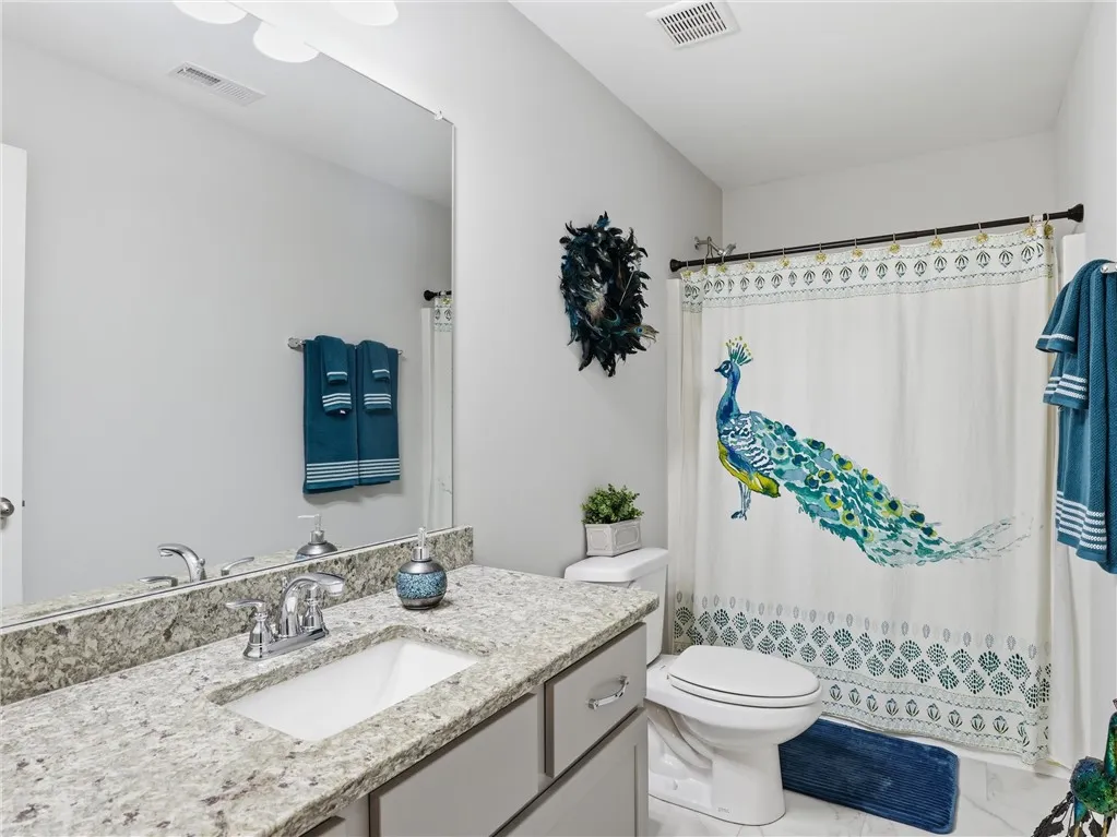 Granite counters and a clean white vanity offer a fresh, modern bathroom aesthetic.