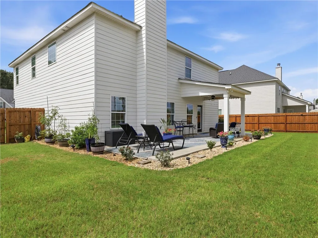A private, fenced yard boasts a spacious covered patio, perfect for outdoor relaxation and entertaining.