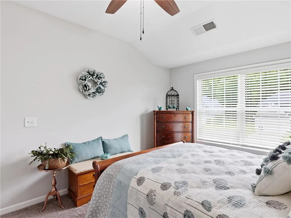 Sloped ceilings and a wide window frame this peaceful bedroom.