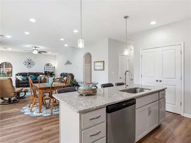 An open-concept living area boasts a sleek kitchen island with granite countertops, seamlessly connecting to the dining and living spaces.