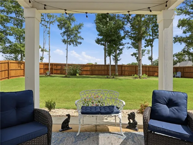 A spacious backyard with mature trees provides a peaceful outdoor retreat.