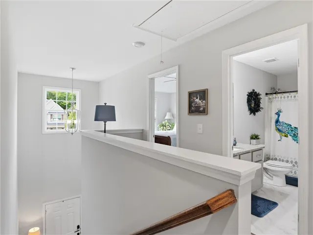 An inviting upstairs landing features an attic access point, leading to well-appointed rooms and a luminous bathroom.