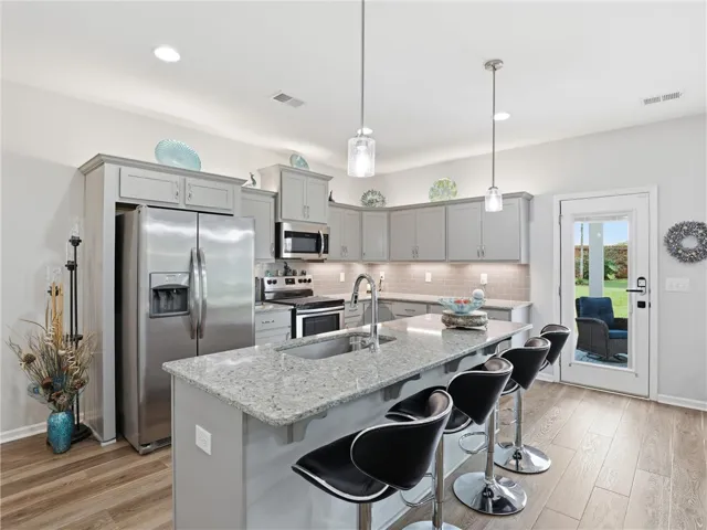 A well-appointed kitchen features a large island with seating, ample cabinetry, and stainless steel appliances.