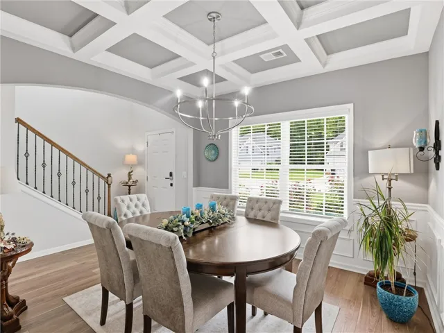 Ornate coffered ceilings and rich hardwood flooring define this elegant dining room, perfect for entertaining.