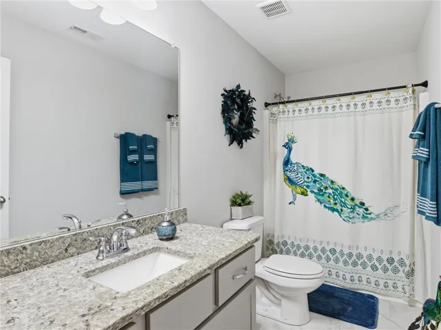 Granite counters and a clean white vanity offer a fresh, modern bathroom aesthetic.
