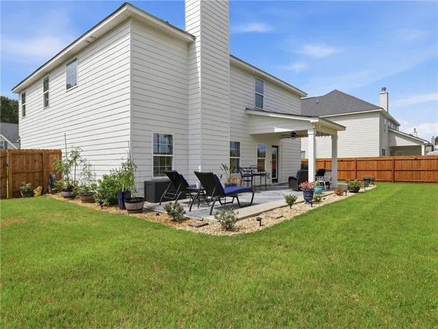 A private, fenced yard boasts a spacious covered patio, perfect for outdoor relaxation and entertaining.
