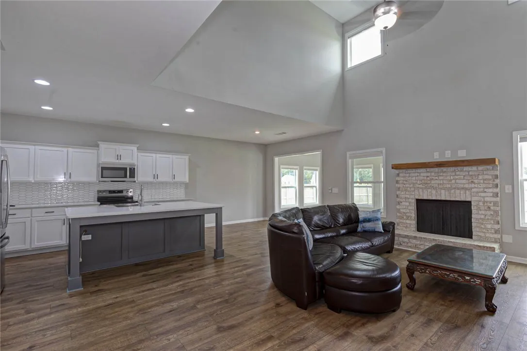 An open concept living area seamlessly connects a modern kitchen and a welcoming family room with a stately fireplace.