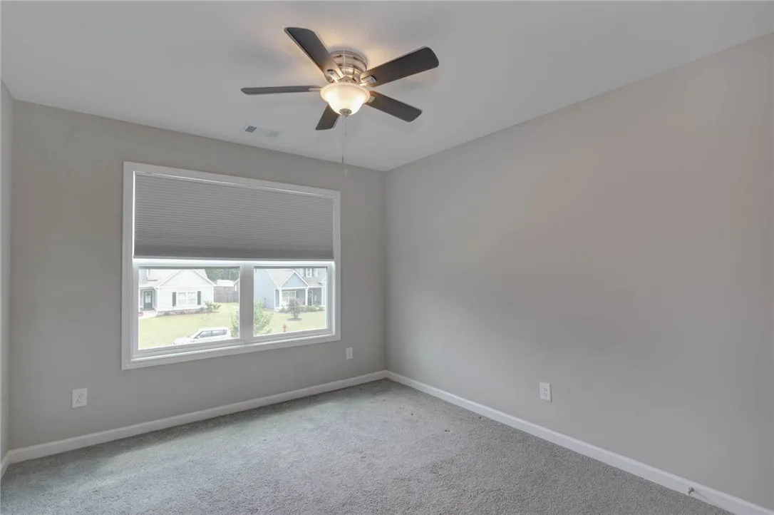 An inviting room features a generous window overlooking the neighborhood and soft carpeting for ultimate comfort.