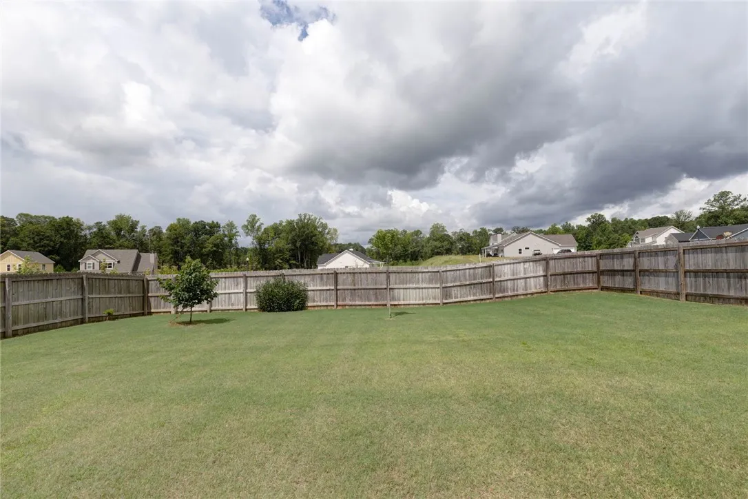 Fenced backyard provides a spacious, private lawn for outdoor enjoyment.