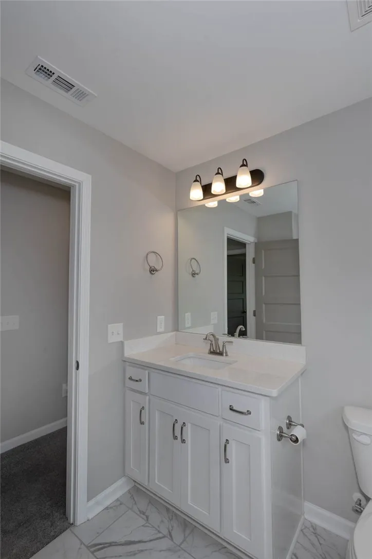 A well-appointed bathroom with a spacious vanity, sleek countertops, and reflective mirror offers both style and functionality.