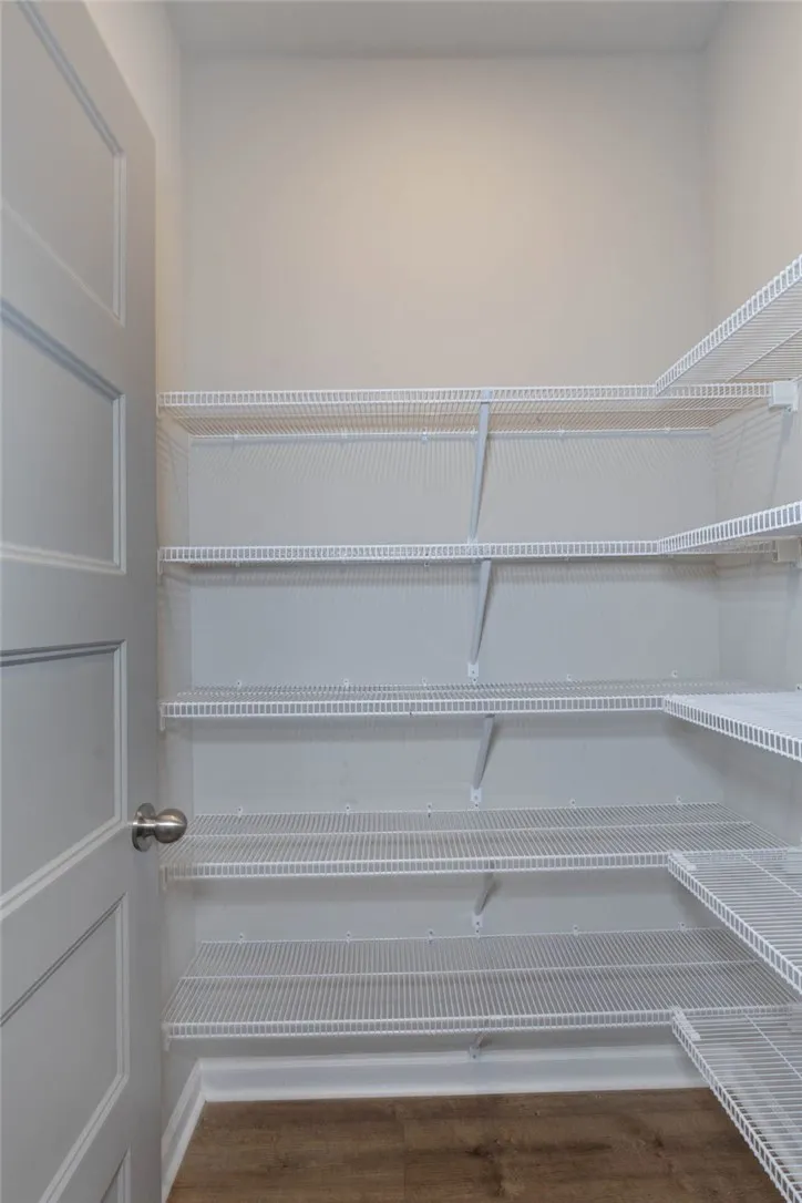 Well-organized pantry features wire shelving and durable flooring, ensuring ample storage.
