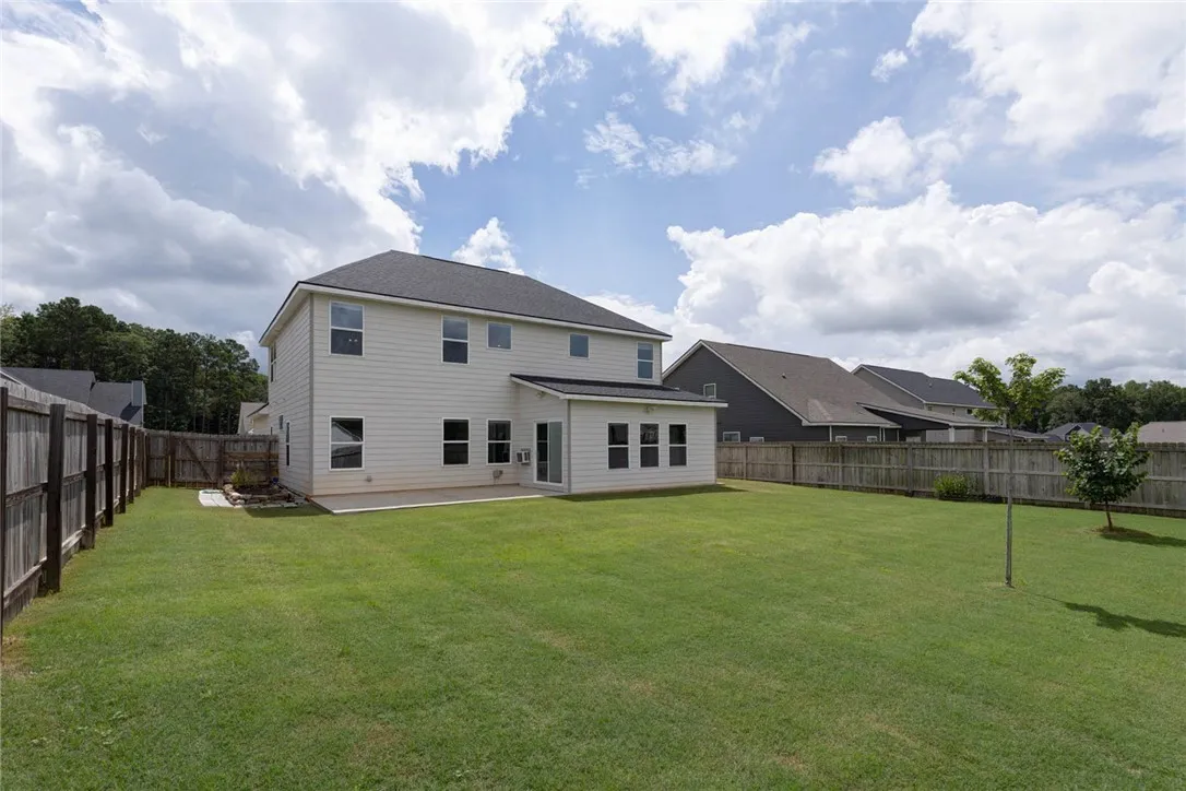 A fenced backyard offers ample green space and a sunroom addition for relaxed outdoor living.