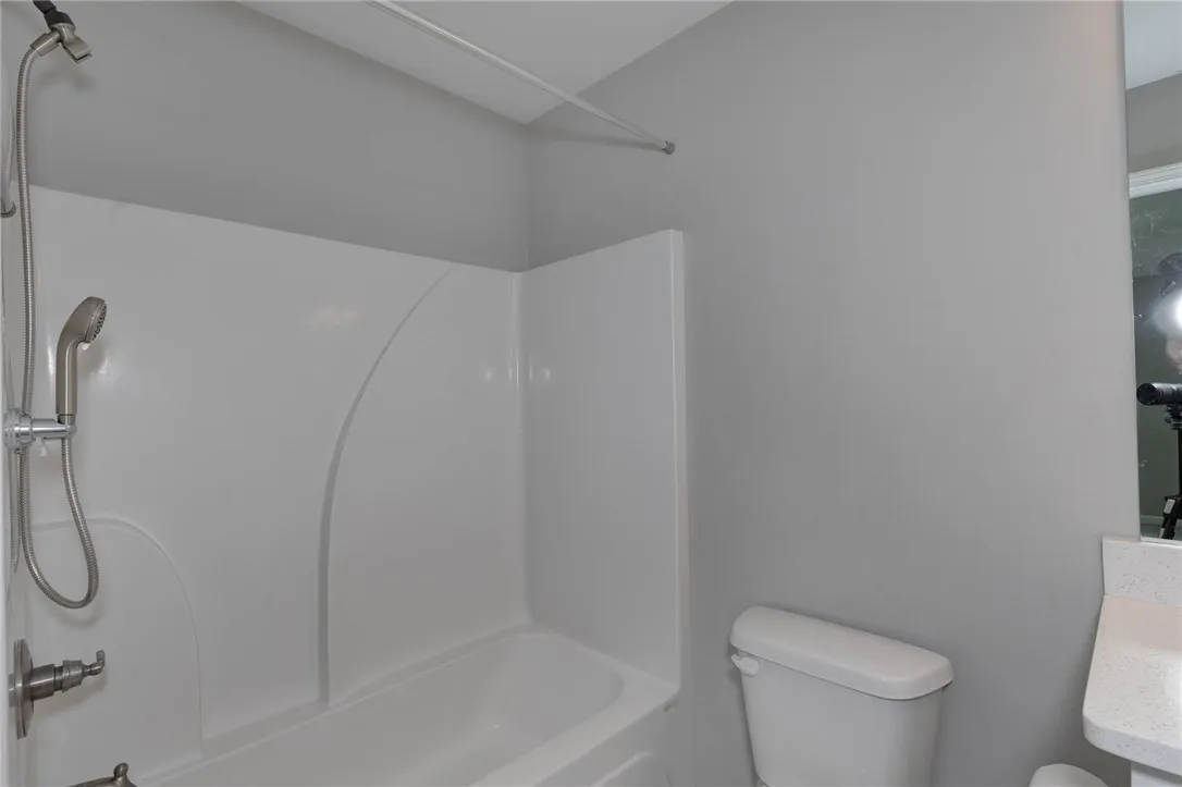 A well-maintained bathroom featuring a practical shower-tub combination and essential fixtures.