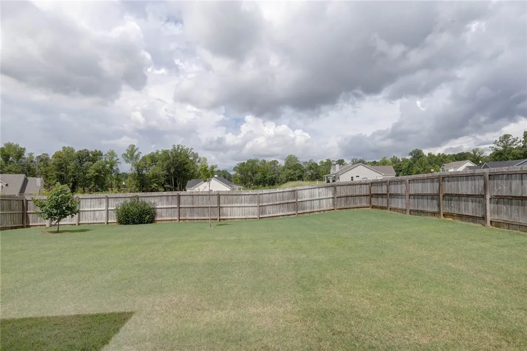A generously sized yard, fully enclosed with a privacy fence, offers ample space for outdoor enjoyment.