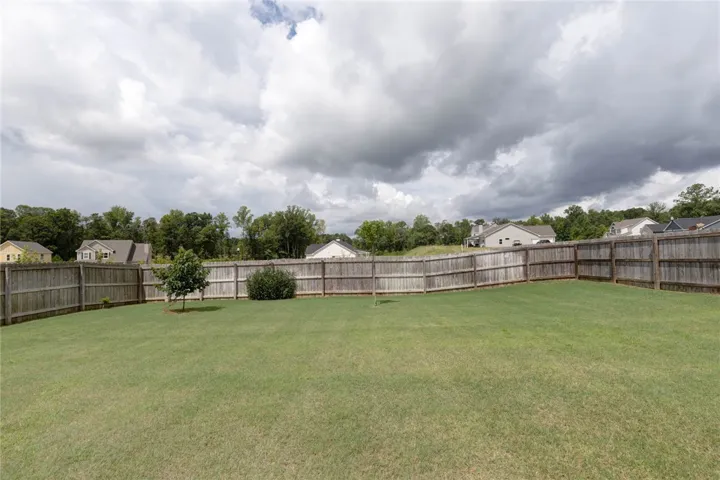 Fenced backyard provides a spacious, private lawn for outdoor enjoyment.