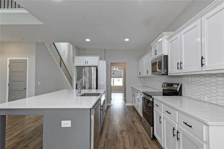 A well-appointed kitchen features stainless steel appliances, gleaming countertops, and durable flooring, creating an inviting space for culinary endeavors.
