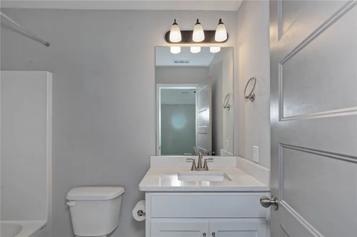 A well-appointed bath features a sleek vanity, ample mirror, and modern lighting fixtures.