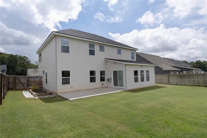 A spacious backyard with a concrete patio awaits outdoor entertaining.