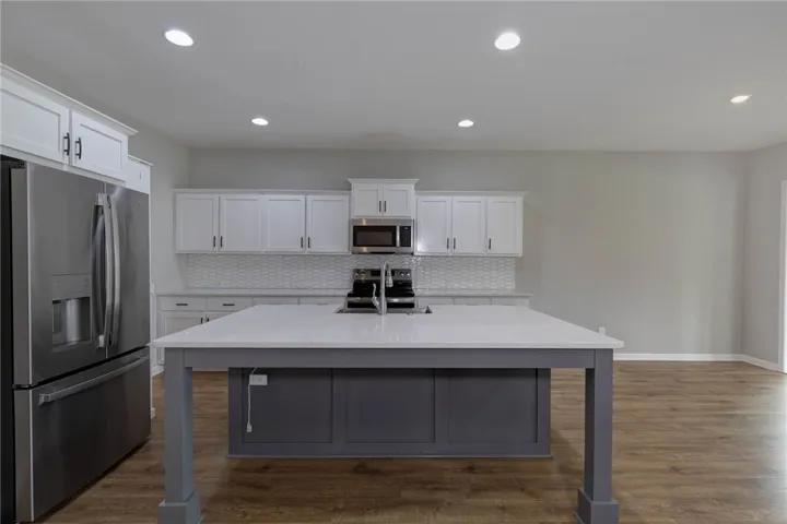 A well-appointed kitchen features a central island, modern appliances, and ample cabinetry for culinary pursuits.
