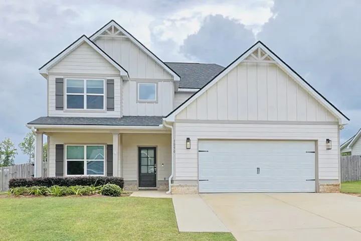 A well-maintained facade with modern farmhouse elements and manicured landscaping creates a welcoming first impression.