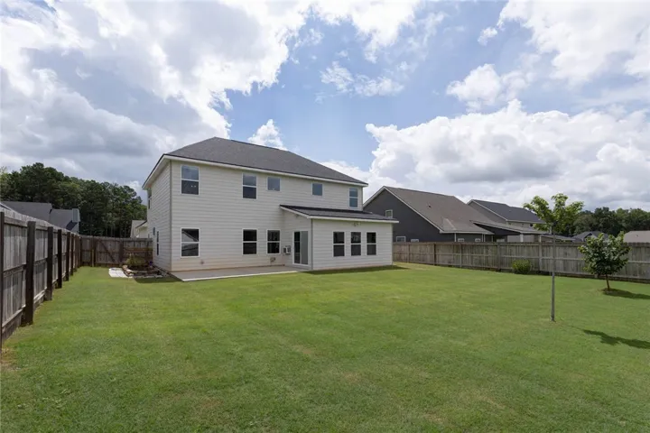 A fenced backyard offers ample green space and a sunroom addition for relaxed outdoor living.