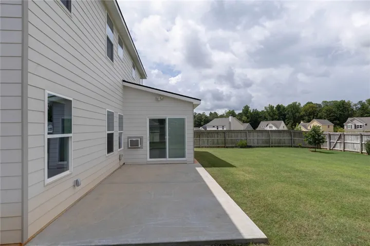 A spacious backyard with a concrete patio awaits outdoor entertaining.