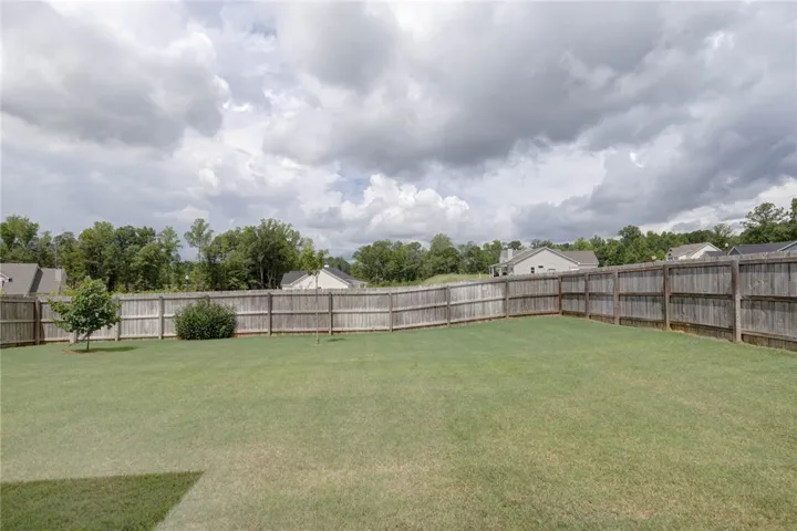 A generously sized yard, fully enclosed with a privacy fence, offers ample space for outdoor enjoyment.