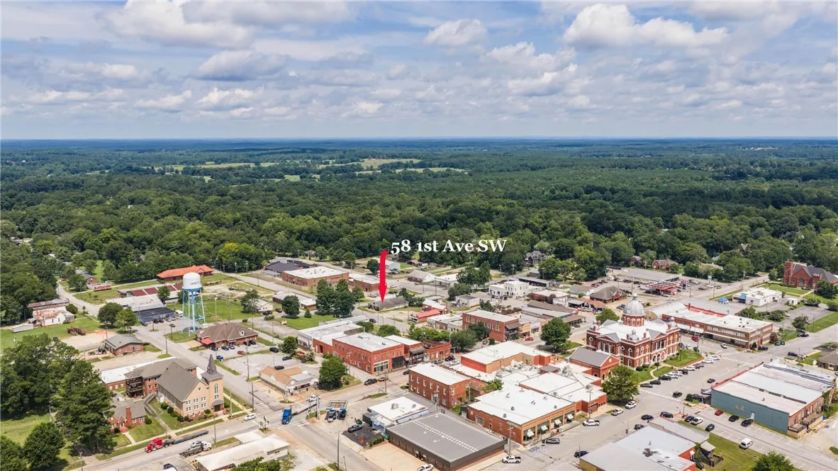 An aerial perspective reveals the property nestled within a vibrant downtown landscape, surrounded by verdant forests.