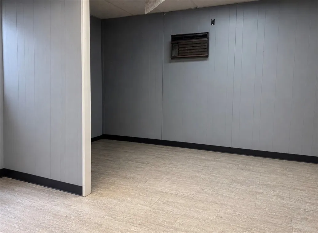 A well-maintained basement room featuring durable flooring and paneling.