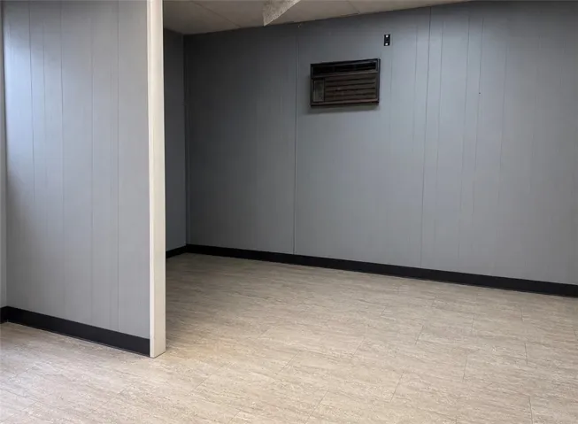 A well-maintained basement room featuring durable flooring and paneling.