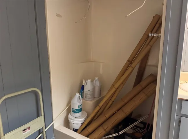 This image captures a shower stall serving as an auxiliary storage space.