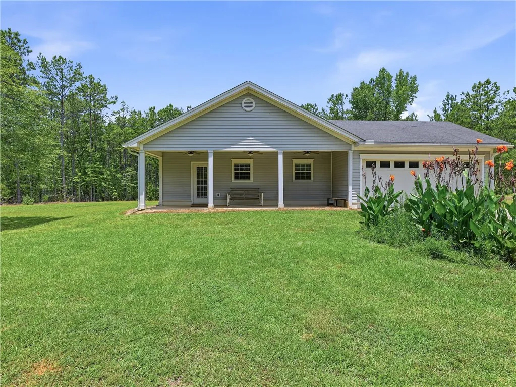 A welcoming covered porch and integrated garage complement this tranquil, treed residential setting.
