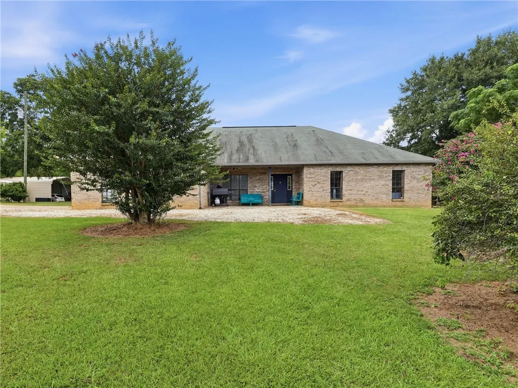 Main home is aclassic brick facade complements the expansive green lawn, offering a welcoming outdoor environment.