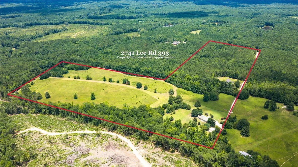 An aerial perspective reveals a vast estate with verdant pastures bordered by mature woodlands, perfect for private living.
