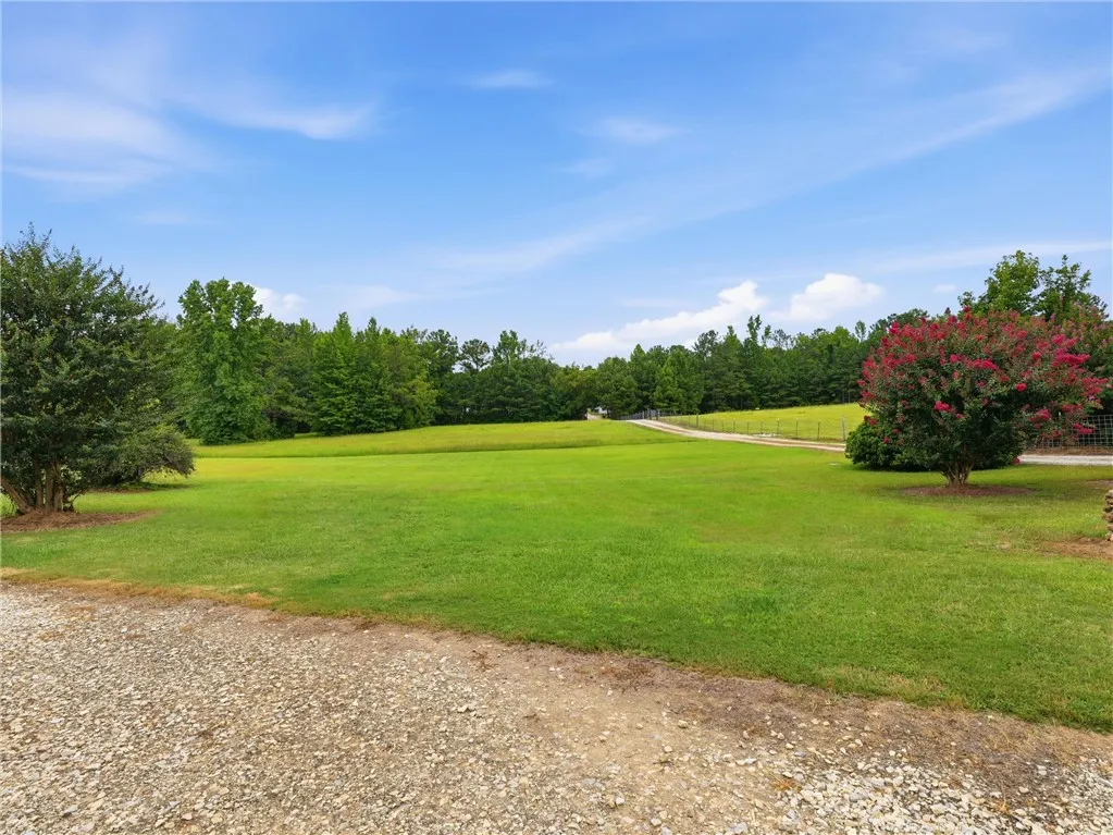 A winding gravel drive leads to a secluded estate nestled within abundant acreage.