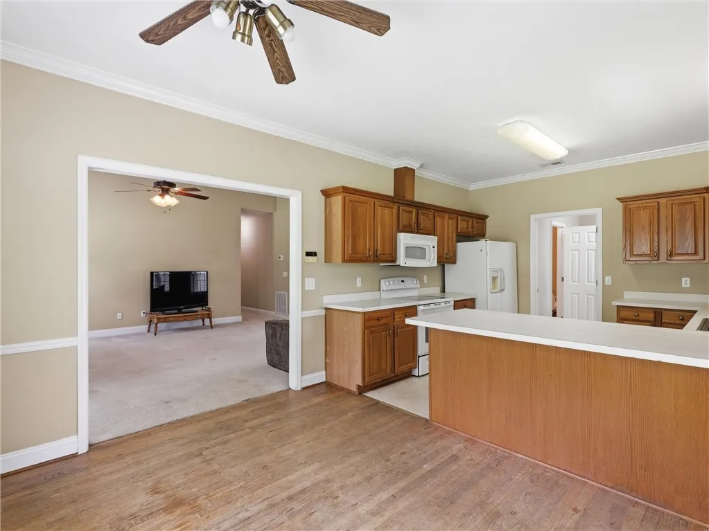An inviting kitchen with wood cabinetry and an open layout flows into an adjacent living space.