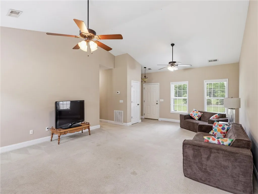 Well-lit living room with vaulted ceilings and abundant natural light.