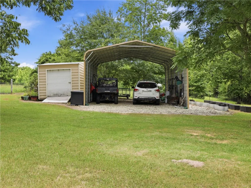 A spacious carport and storage shed complement this verdant, open lot.