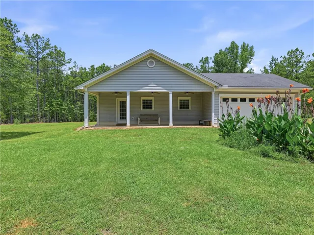 A welcoming covered porch and integrated garage complement this tranquil, treed residential setting.