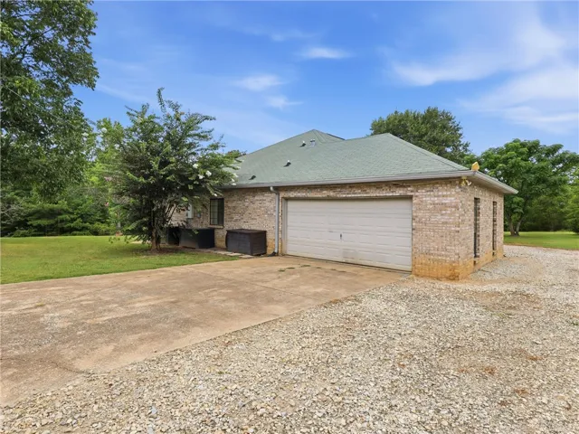 A well-maintained brick structure offers convenient garage access and ample outdoor space.