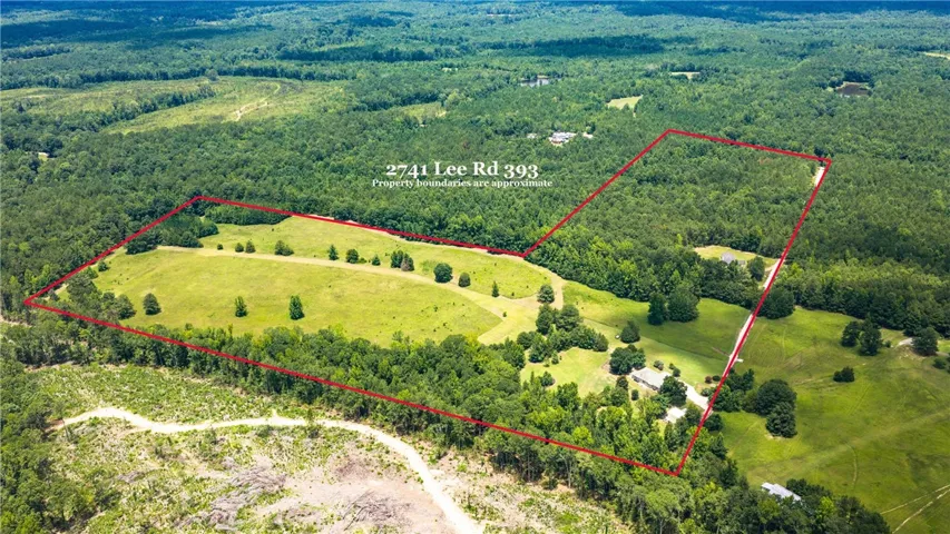 An aerial perspective reveals a vast estate with verdant pastures bordered by mature woodlands, perfect for private living.