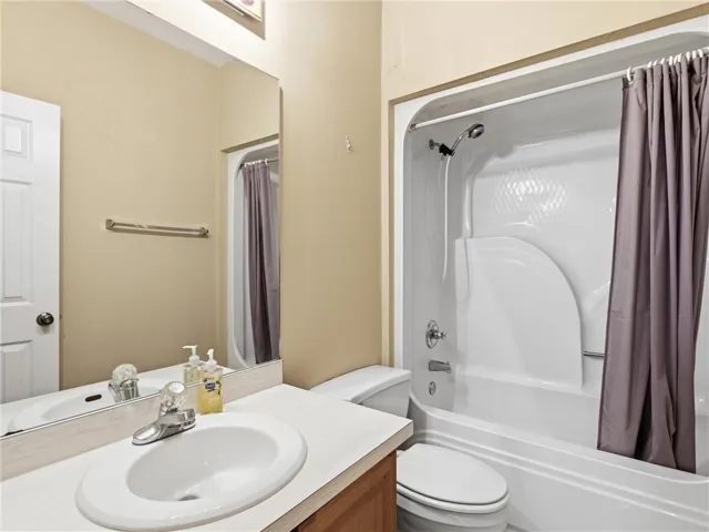 A well-maintained full bathroom presents a tub-shower combination and a vanity with an integrated sink.