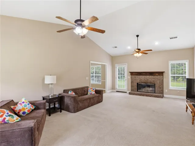 A welcoming living area boasts soaring vaulted ceilings, cozy fireplace, and abundant natural light.