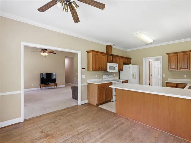 An inviting kitchen with wood cabinetry and an open layout flows into an adjacent living space.