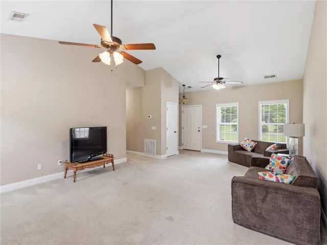 Well-lit living room with vaulted ceilings and abundant natural light.