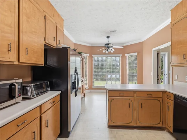 A well-lit kitchen with natural wood cabinetry and a spacious island for meal preparation.