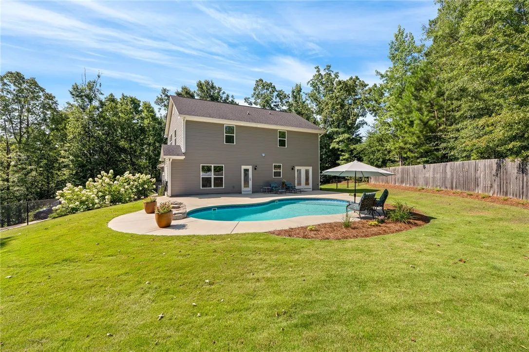 A private backyard oasis features an in-ground pool and ample green space for leisure.