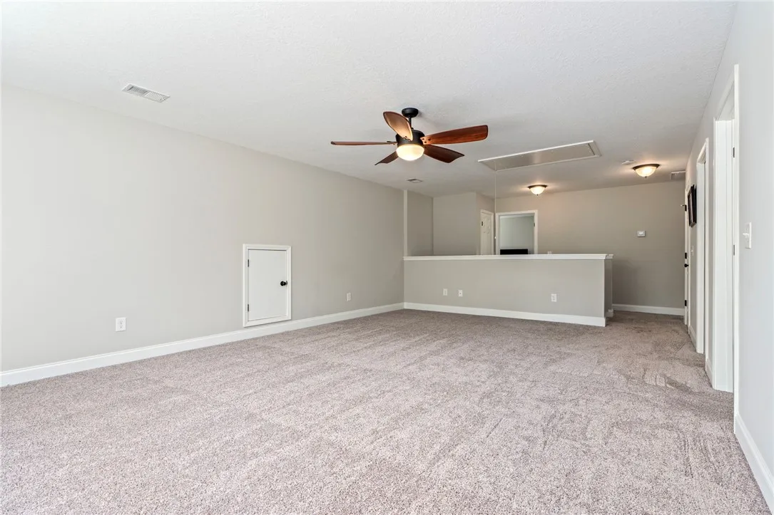 A spacious carpeted loft area provides versatile living space with overhead illumination.