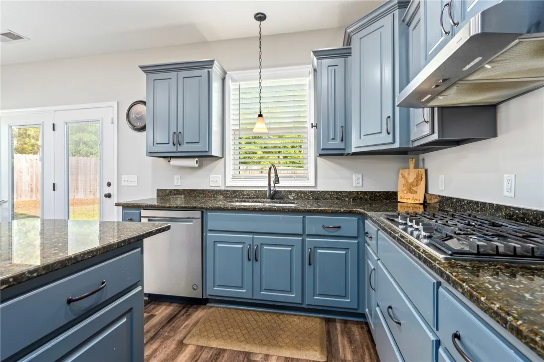 A well-appointed kitchen showcasing elegant blue cabinetry paired with lustrous granite countertops.